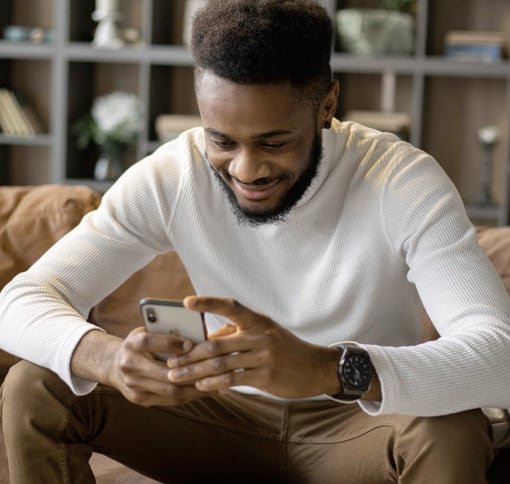 a man smiling while looking at his phone